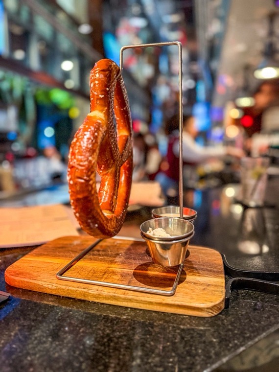 Warm salted pretzel served on a hanging rack
